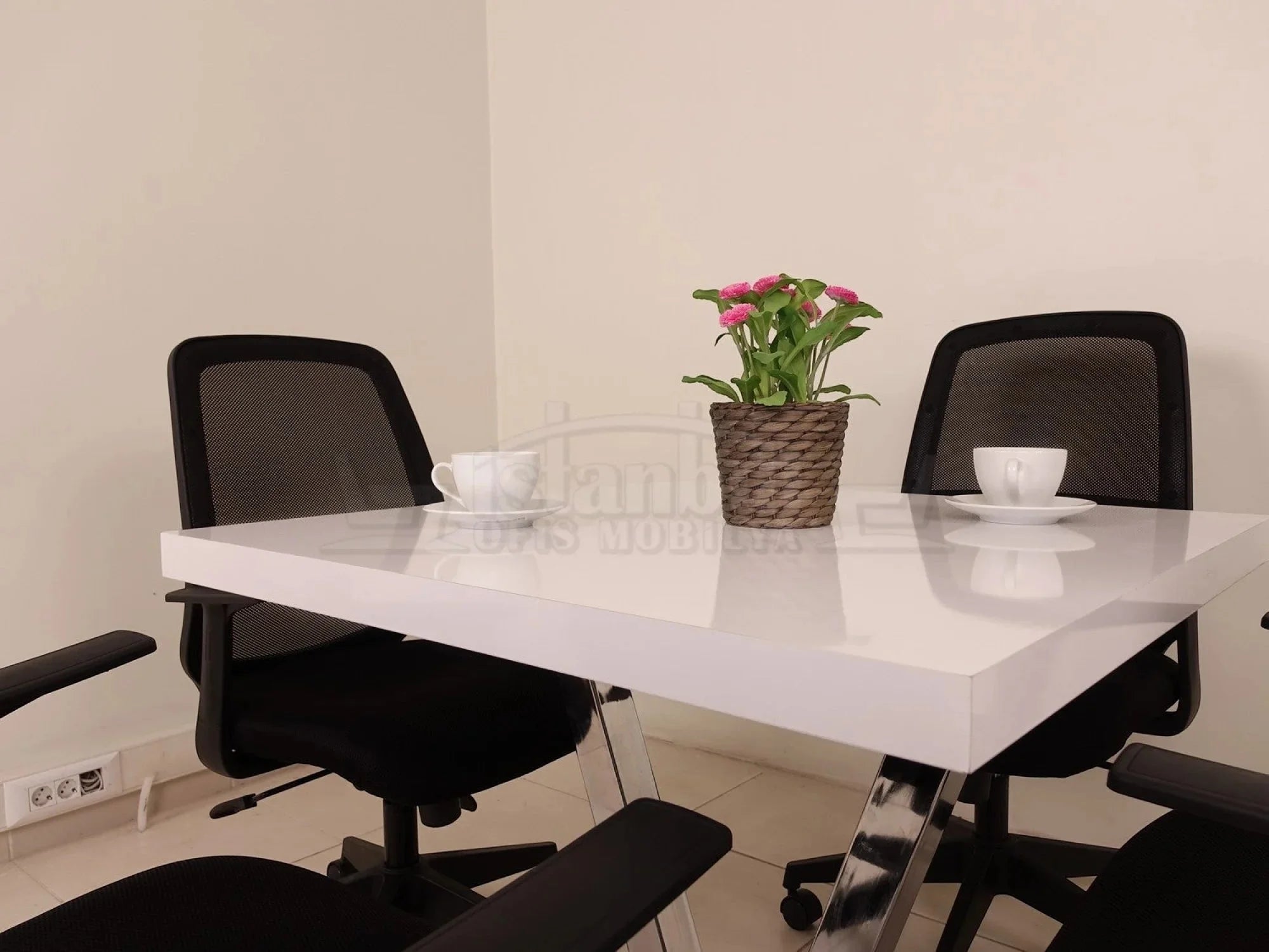 İstanbul Ofis Mobilya marka beyaz parlak yüzeyli, V formunda krom ayaklı modern kare ofis ve toplantı masası.